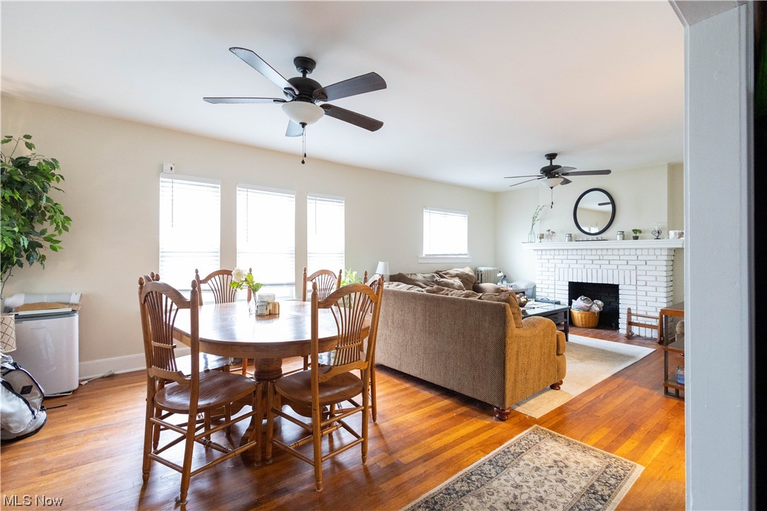 2261 Maplewood Road Cleveland, OH 44118 - Photo 5 of 44 Dining room with light hardwood / wood-style flooring, ceiling fan, and a brick fireplace