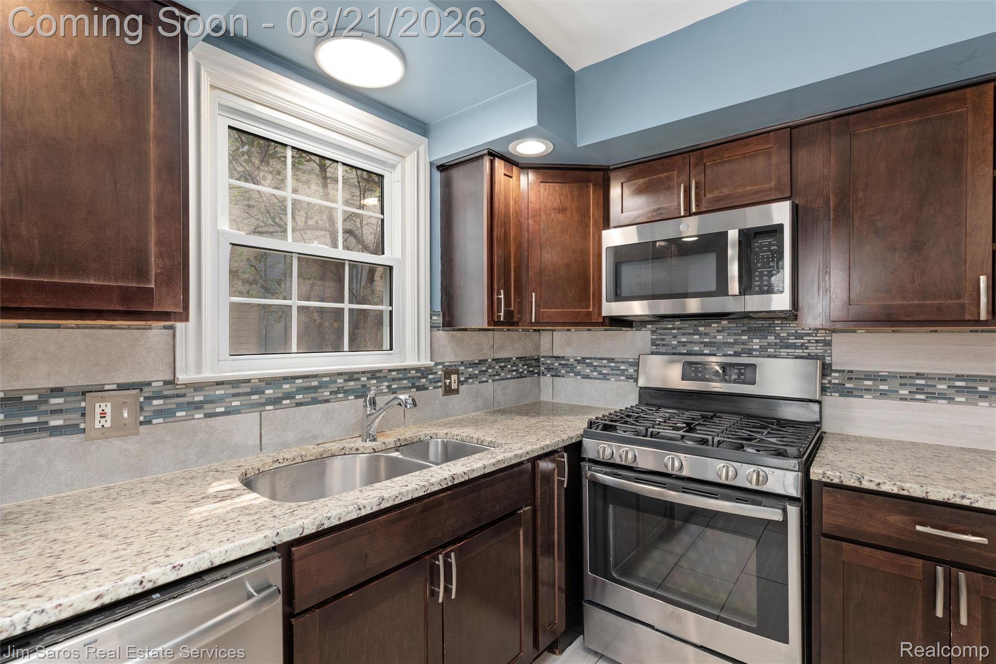 288 Moran Road Grosse Pointe, MI 48236 - Photo 7 of 24 Stainless steel appliances, granite-style countertops, mosaic tile backsplash, wood-finish cabinetry, and a double-basin sink