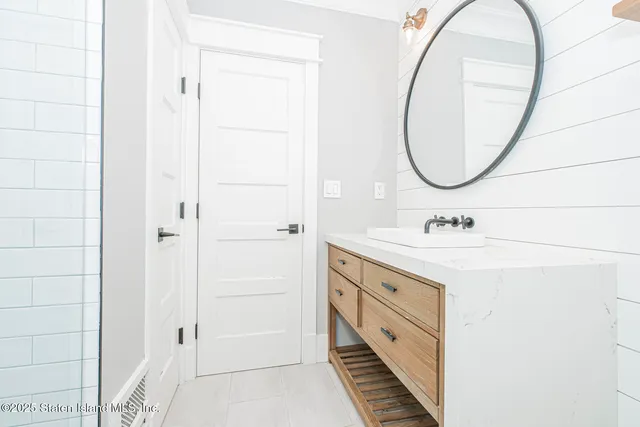 a spacious bathroom with a double vanity sink a mirror and a shower