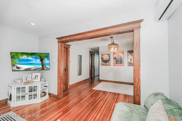 a view of a livingroom with wooden floor and a flat screen tv