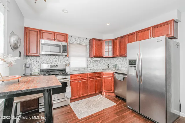 a kitchen with stainless steel appliances granite countertop a refrigerator and a stove top oven