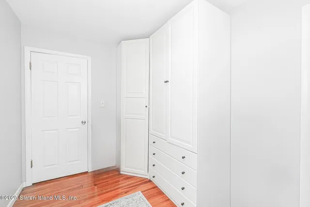 a view of a bedroom with wooden floor