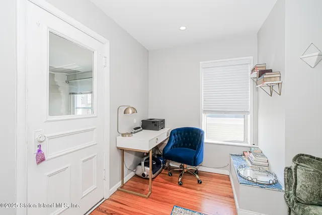 a view of a workspace with furniture and a window