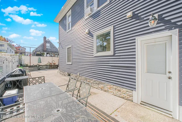a view of a patio with couches and table and chairs and potted plants