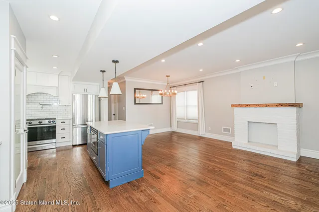 a large kitchen with stainless steel appliances granite countertop a stove and a refrigerator