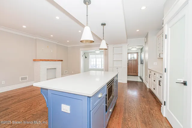 a kitchen with kitchen island a sink stove and wooden floor