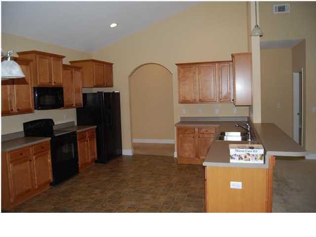 473 Lime Crestview, FL 32536 - Photo 4 of 16 a kitchen with stainless steel appliances granite countertop a refrigerator a stove and a sink with wooden floor