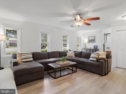 a living room with furniture a ceiling fan and a window