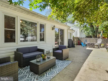 a view of a patio with couches and a table and chairs with wooden floor