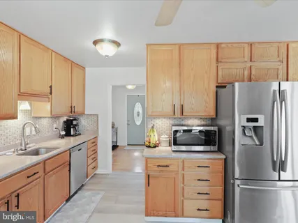 a kitchen with a refrigerator sink and cabinets