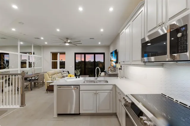 a living room with furniture a flat screen tv and a floor to ceiling window