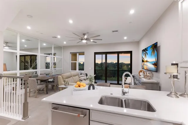 a living room with furniture a flat screen tv and a floor to ceiling window