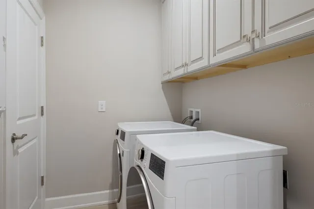 a view of a big house with a big yard plants and large trees