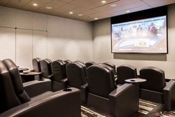 a media room with lots of chairs and a projector screen