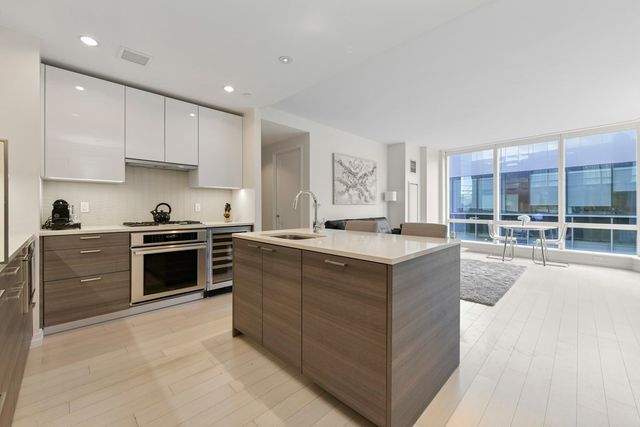 a kitchen with stainless steel appliances granite countertop a stove top oven and cabinets