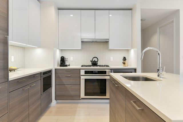 a kitchen with cabinets appliances a sink and a counter top space
