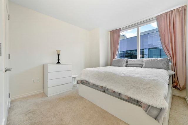 a bedroom with a bed and a large window