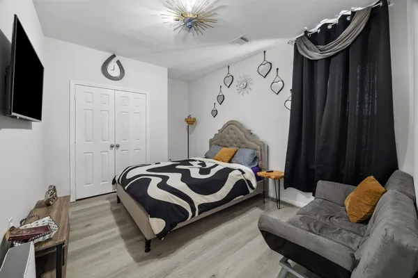 a bedroom with a bed and wooden floor