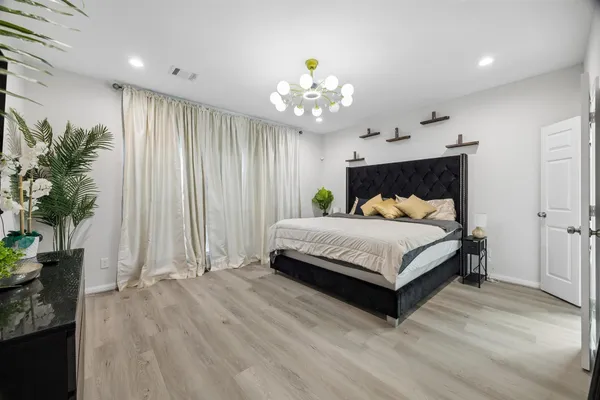 a bedroom with a large bed and a chandelier