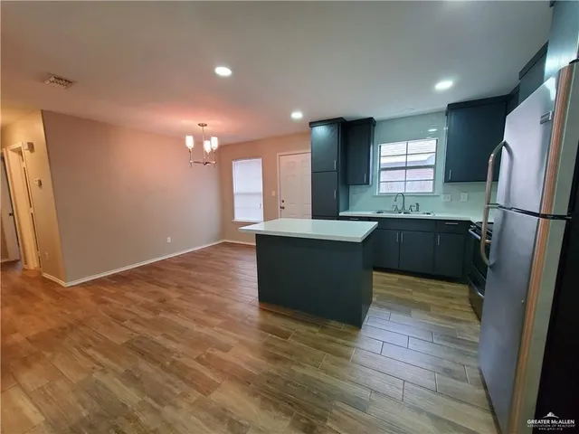 a kitchen with stainless steel appliances granite countertop a sink a refrigerator and a stove