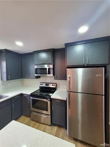 a kitchen with a refrigerator and a stove top oven