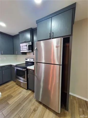 a kitchen with a refrigerator and a stove top oven