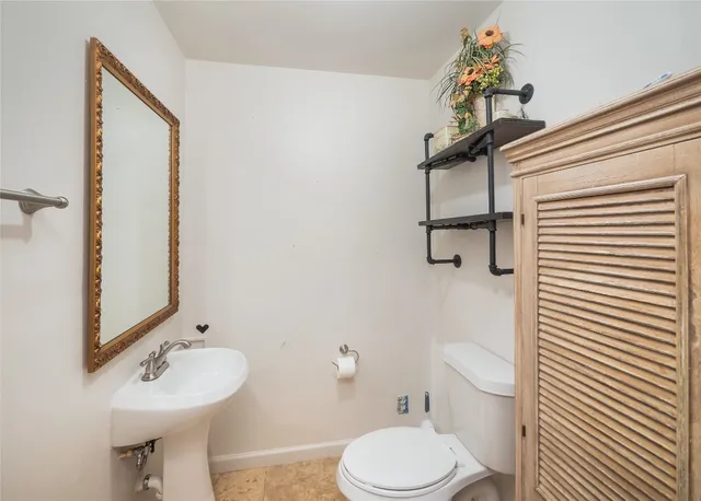 a bathroom with a sink a toilet and shower curtain