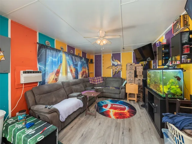 a living room with furniture a flat screen tv and a floor to ceiling window