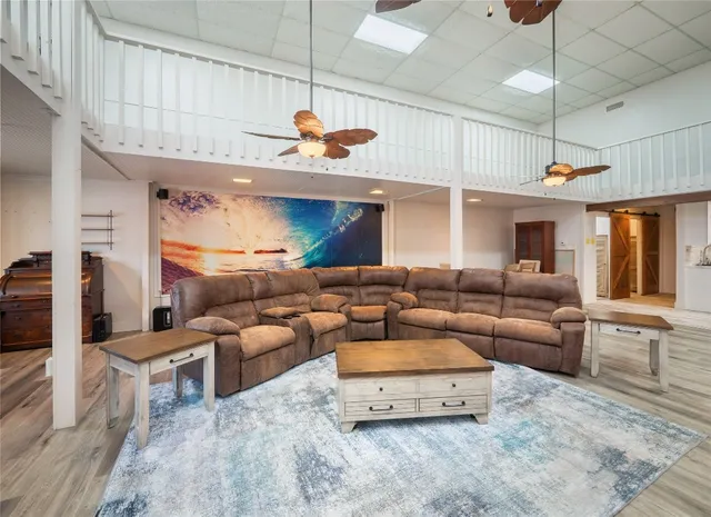 a living room with furniture kitchen view and a chandelier