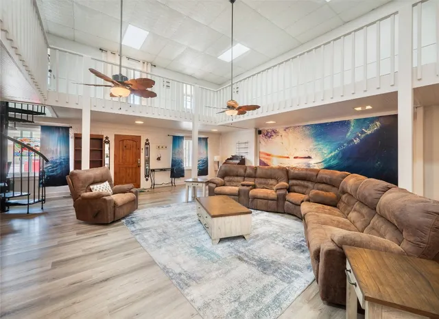 a living room with furniture kitchen view and a chandelier
