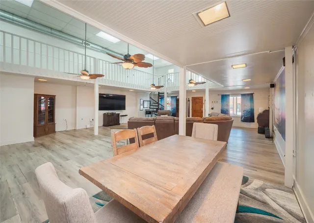 a large living room with stainless steel appliances kitchen island granite countertop furniture and a fireplace