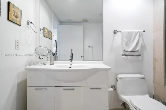 a bathroom with a sink toilet and mirror