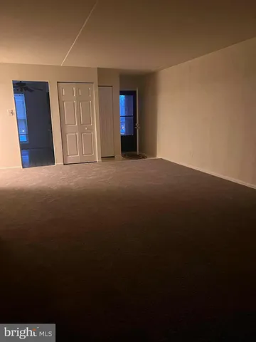 a view of a hallway with wooden floor and a livingroom