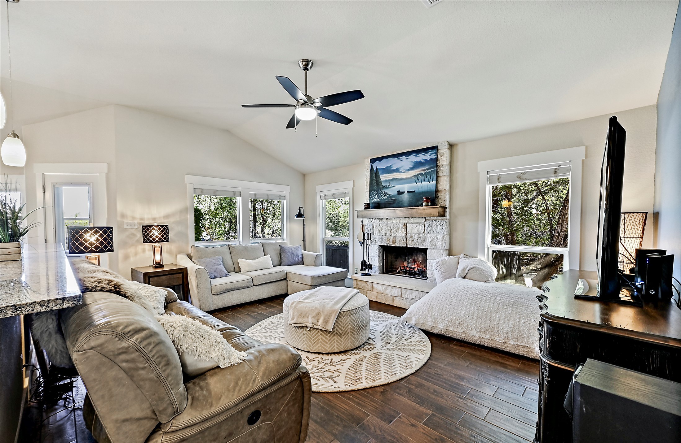 a living room with furniture fireplace and a large window