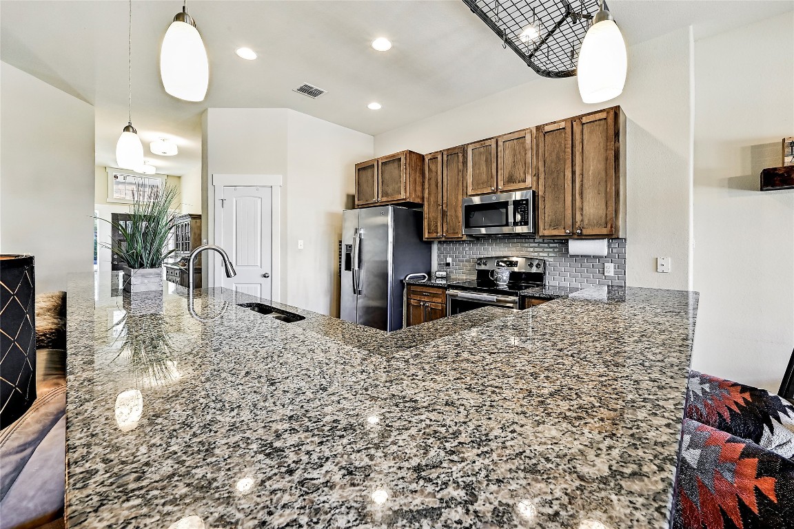 1 Rolling Hills Road Wimberley, TX 78676 - Photo 11 of 30 a kitchen with stainless steel appliances granite countertop a refrigerator stove top oven and sink