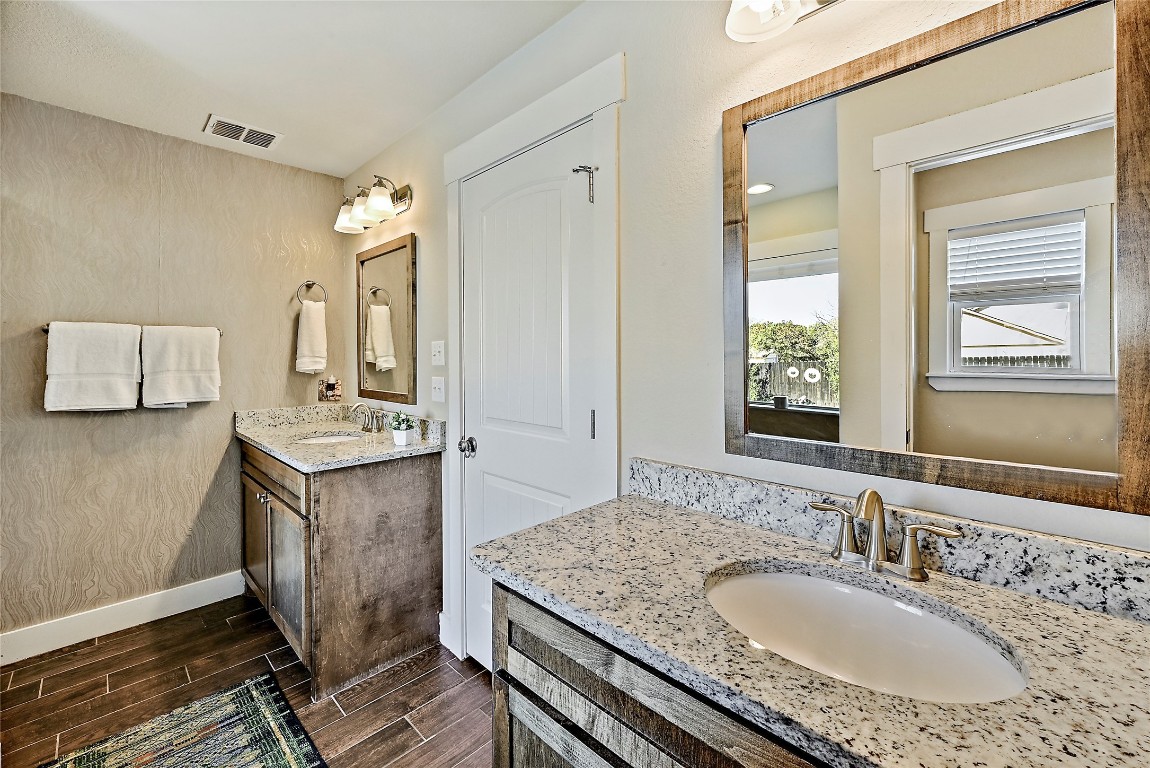 1 Rolling Hills Road Wimberley, TX 78676 - Photo 18 of 30 a bathroom with a granite countertop sink a mirror and a shower