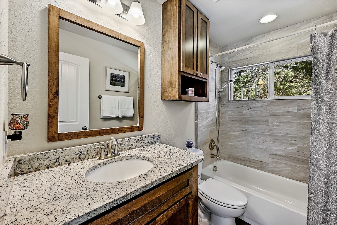 1 Rolling Hills Road Wimberley, TX 78676 - Photo 21 of 30 a bathroom with a granite countertop sink toilet and shower