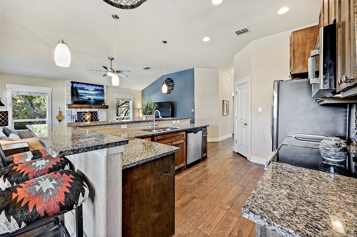 1 Rolling Hills Road Wimberley, TX 78676 - Photo 30 of 30 a kitchen with stainless steel appliances granite countertop a sink refrigerator and microwave