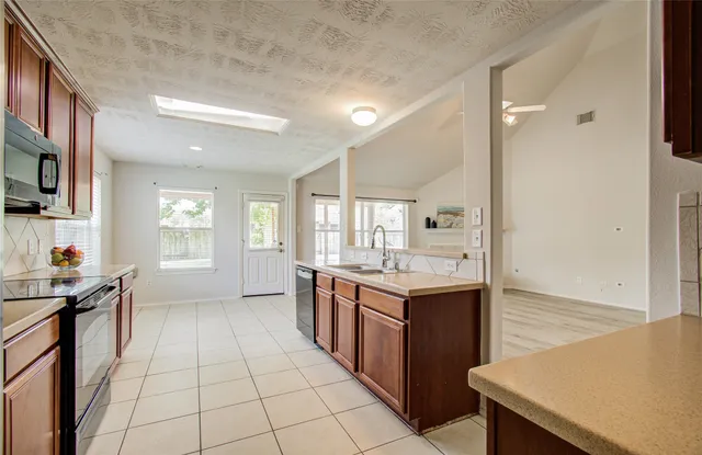 a kitchen with a sink a stove and cabinets