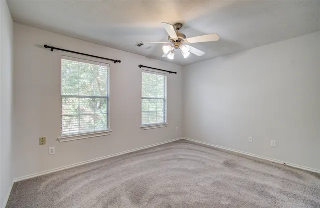 an empty room with a chandelier fan