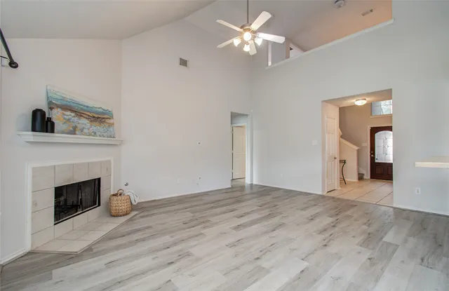 a view of empty room with wooden floor and fireplace