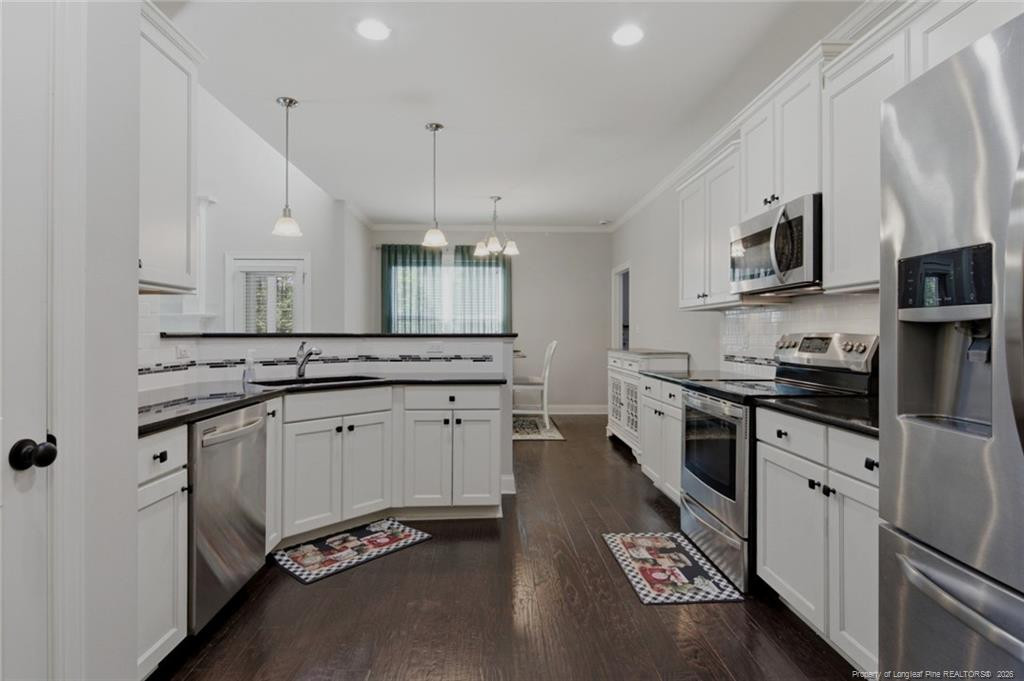 95 Valley Brook Lane Spring Lake, NC 28390 - Photo 17 of 49 a large kitchen with stainless steel appliances a large counter top a stove a chimney a sink and a refrigerator