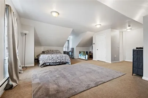 a bedroom with a bed and a large mirror on dresser