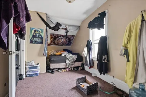 a view of a white house with a small yard and large tree