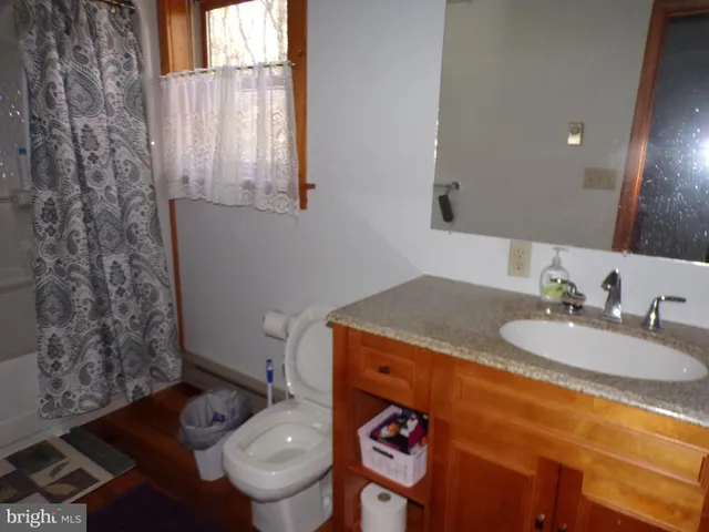 a bed in a bedroom next to a window with a flat screen tv