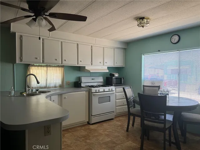 a kitchen with a table chairs and white cabinets