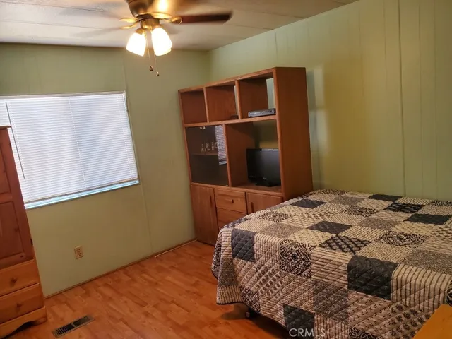 a bedroom with a bed and a ceiling fan