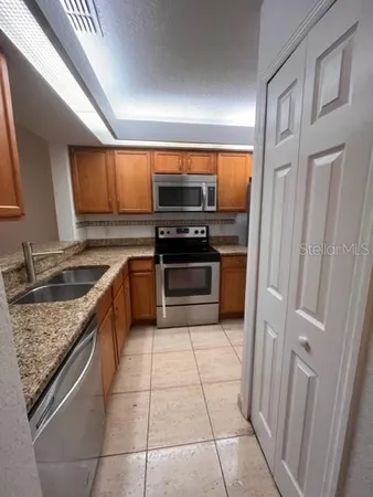 a kitchen with a stove sink and cabinets
