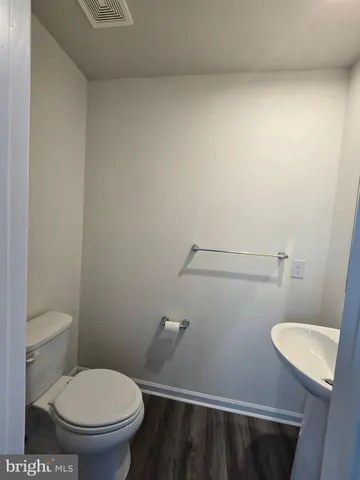 a white toilet sitting next to a white wall