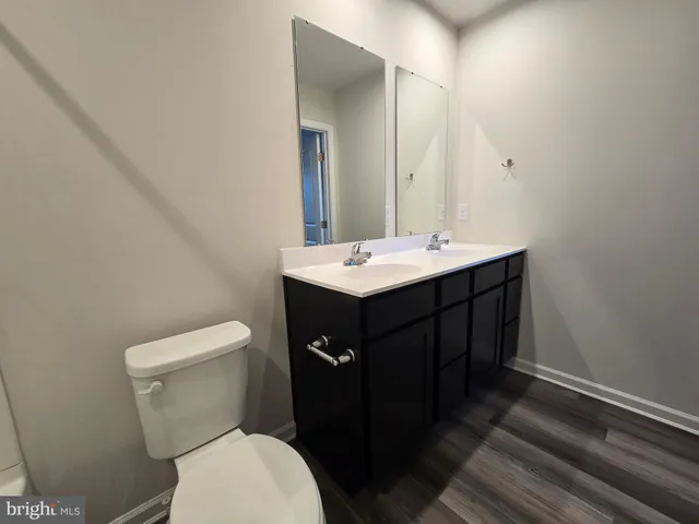 a bathroom with a sink vanity mirror and toilet